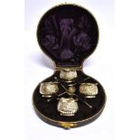 A CASED SET OF FOUR VICTORIAN SILVER SALTS AND SPOONS the cauldron form salts spiral fluted with