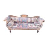 A REGENCY CARVED MAHOGANY SCROLL END SOFA on fluted supports, with kilim upholstery, a folding frame