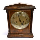 AN EDWARDIAN OAK MANTLE CLOCK with inlaid decoration, the 8-day movement striking on a coiled gong