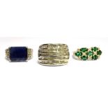 THREE SILVER DRESS RINGS comprising a diamond set five row band ring, an emerald and diamond three
