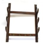 A WOODEN WHIP RACK with three twin brackets, for wall mounting, 90cm high x 72cm wide