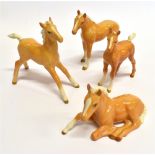 FOUR BESWICK FIGURES OF A PALOMINO FOALS the largest 12cm high