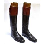A PAIR OF GENTS BLACK LEATHER HUNTING BOOTS with brown tops, the wooden trees with brass ring pull