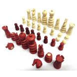 A LATE 19TH CENTURY CARVED IVORY CHESS SET natural white and stained red, the kings 8.25cm high (red