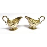 A PAIR OF GEORGIAN SILVER SAUCE BOATS The helmet shaped boats with curved grooved decoration,