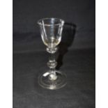 AN 18TH CENTURY WINE GLASS with bell shaped bowl and triple knopped plain stem, on conical folded