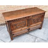 AN OAK MULE CHEST the two plank top with moulded edge, the front with carved decoration, initials