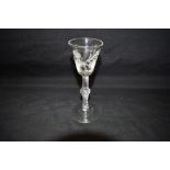 AN 18TH CENTURY WINE GLASS the bell shaped bowl engraved with flowers and a moth, on knopped air