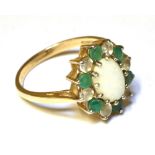 AN OPAL, EMERALD AND WHITE STONE OVAL CLUSTER DRESS RING Claw settings to a 9ct yellow gold shank,