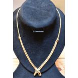 AN 18CT YELLOW GOLD NECKLACE With cross over double drop front set with small green and red