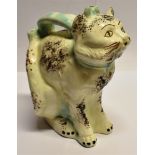 A CONTINENTAL FAIENCE JUG MODELLED AS A SEATED CAT with painted and sponged decoration, 27cm high