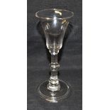 AN 18TH CENTURY WINE GLASS with trumpet shaped bow, on triple knopped plain stem and conical