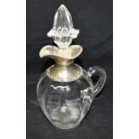 A SILVER TOPPED GLASS CLARET JUG The silver top with pouring spout, no lid, scroll borders,