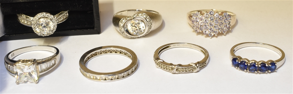 A GROUP OF SEVEN STONE SET SILVER RINGS the assorted designs set with white stones and one with a