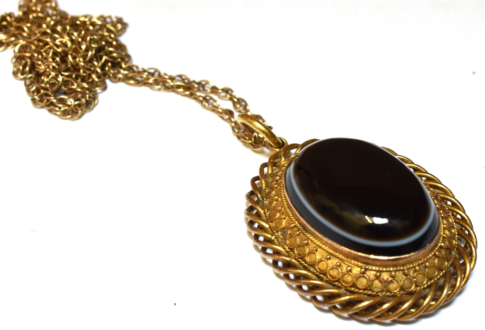 A VICTORIAN BANDED BLACK AGATE OVAL PENDANT And later 9ct gold chain, the Etruscan style oval