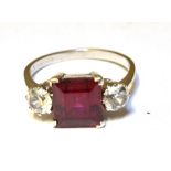 A SYNTHETIC RUBY AND SYNTHETIC WHITE SPINEL THREE STONE RING Claw settings to a 9ct white gold