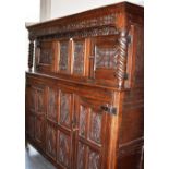 A LARGE OAK 'DUEDDARN' CUPBOARD the frieze carved with initials and date 'A G S 1692', the upper