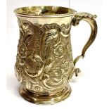 A GEORGIAN SILVER CHRISTENING MUG of baluster form with heavily embossed later floral decoration,