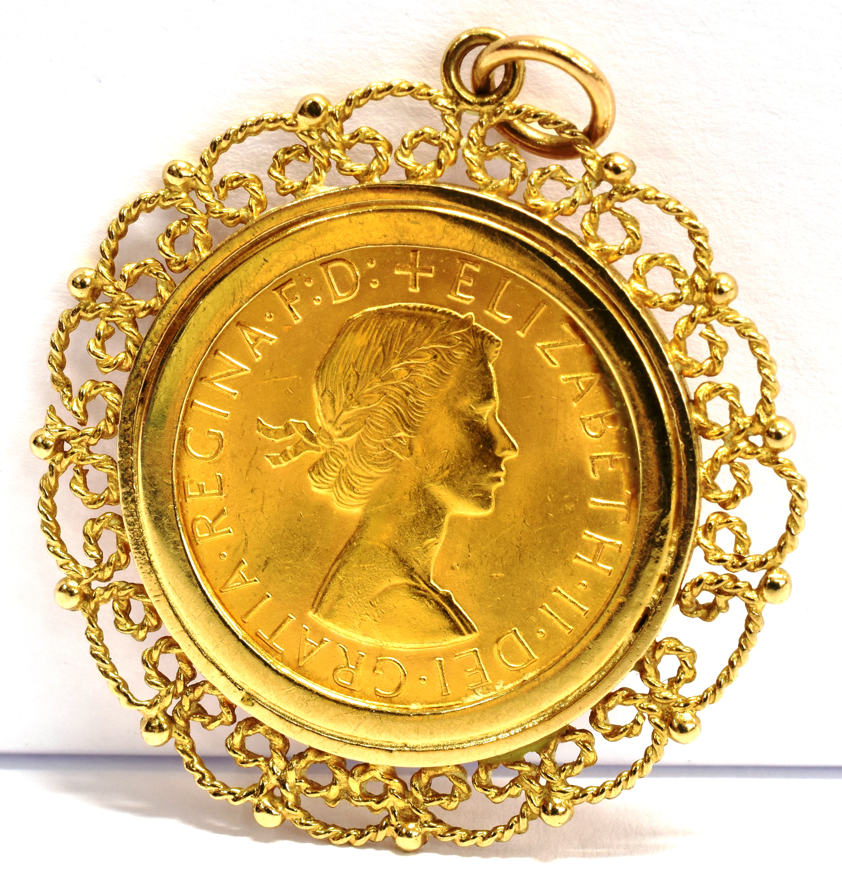 A FULL SOVEREIGN GOLD PENDANT The coin dated 1963 to a 9ct gold filigree pendant mount, gross weight