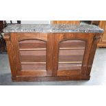 A VICTORIAN MARBLE TOP BOOKCASE with carved corbels, the glazed doors opening to two adjustable