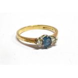 A BLUE TOPAZ AND DIAMOND THREE STONE 9CT GOLD RING the oval cut topaz 5mm x 4mm, a small round