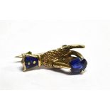 A VICTORIAN MINIATURE HAND BROOCH set with a small sapphire yellow metal, unmarked, 2cm long
