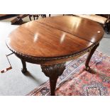 AN EDWARDIAN MAHOGANY EXTENDING DINING TABLE the oval top with gadrooned edge and two additional