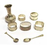 FIVE SILVER NAPKIN RINGS Of assorted designs and date, together with a small Indian silver bud