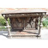 A CARVED OAK BUFFET with frieze drawer flanked by lion masks above carved pilasters and pot shelf