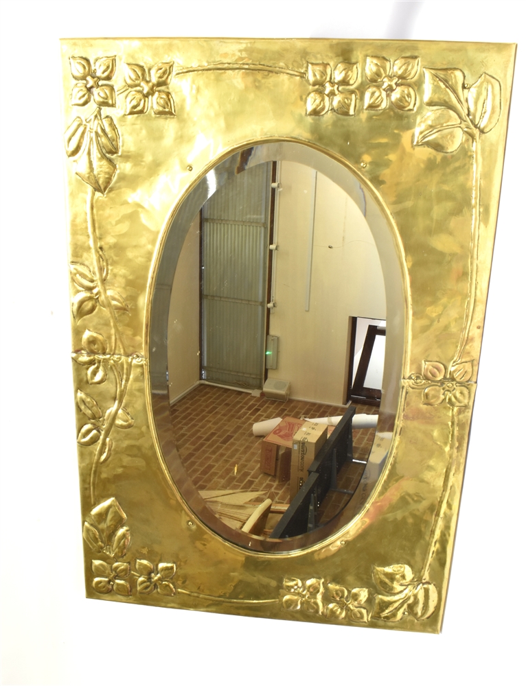 A BRASS FRAMED ARTS & CRAFTS STYLE WALL MIRROR the oval bevelled mirror 34cm x 58cm, the brass frame