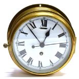 A BRASS CASED SHIPS BULKHEAD CLOCK the enamel dial with Roman hour markers and Arabic minutes,
