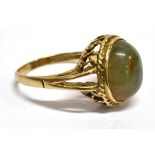 A MODERN MOSS AGATE SINGLE STONE 9CT GOLD DRESS RING The oval cabochon cut agate 12mm x 10mm, 9ct