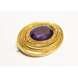 A VICTORIAN AMETHYST SINGLE STONE SET YELLOW GOLD ETRUSCAN STYLE BROOCH the large central amethyst