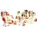 A COLLECTION OF STAFFORDSHIRE SPANIELS the largest piece a figural spill vase 34cm high