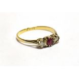 A RUBY AND DIAMOND 18CT GOLD RING small round cut central ruby with a small round brilliant cut