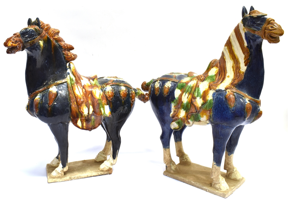 A LARGE PAIR OF CHINESE TANG STYLE FIGURES OF HORSES decorated in sancai glaze, 48cm high