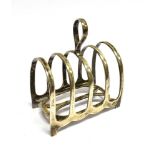 A SILVER FOUR SLICE TOAST RACK Of domed arch design with loop handle, hallmarked Birmingham 1934,