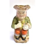 A VICTORIAN STAFFORDSHIRE TOBY JUG typically modelled holding a glass of ale, a jug on his knee,