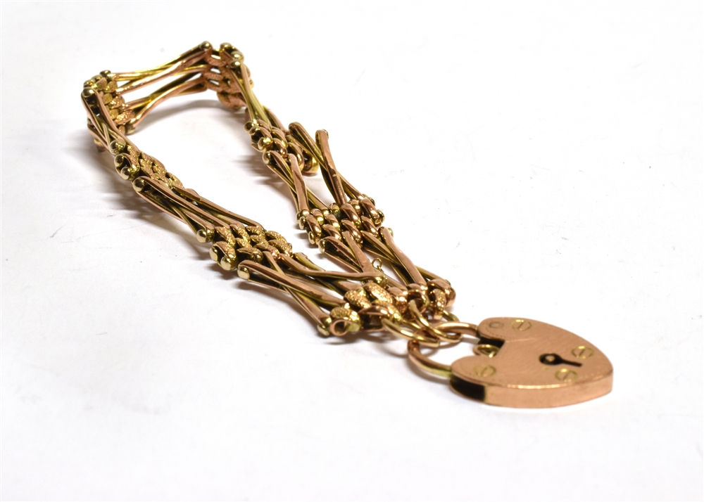 A 9CT ROSE GOLD GATE BRACELET with padlock fastener, cross over four bar pattern (note: two bars