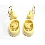 A PAIR OF CARVED ANTIQUE IVORY PANEL DROP EARRINGS the oval openwork drops each intricately carved