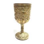 AN ASIAN WHITE METAL GOBLET On a pedestal base, with all over embossed animal scenes and floral