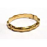 A 9CT GOLD HINGED BANGLE OF BAMBOO DESIGN hallmarked 1964, complete with safety chain, of hollow