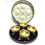 A SET OF FOUR SILVER PLATED ROUND CAULDRON SALTS With gold plated interiors contained in a case.