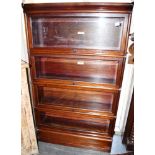 A MAHOGANY GLOBE WERNICKE FOUR TIER SECTIONAL BOOKCASE with bevelled glazed up and over doors, 86.