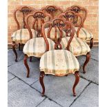 A SET OF SIX VICTORIAN CARVED WALNUT FRAMED DINING CHAIRS with serpentine front overstuffed seats,