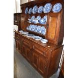 AN OAK DRESSER the top with moulded cornice and two cupboards, the base with three drawers above