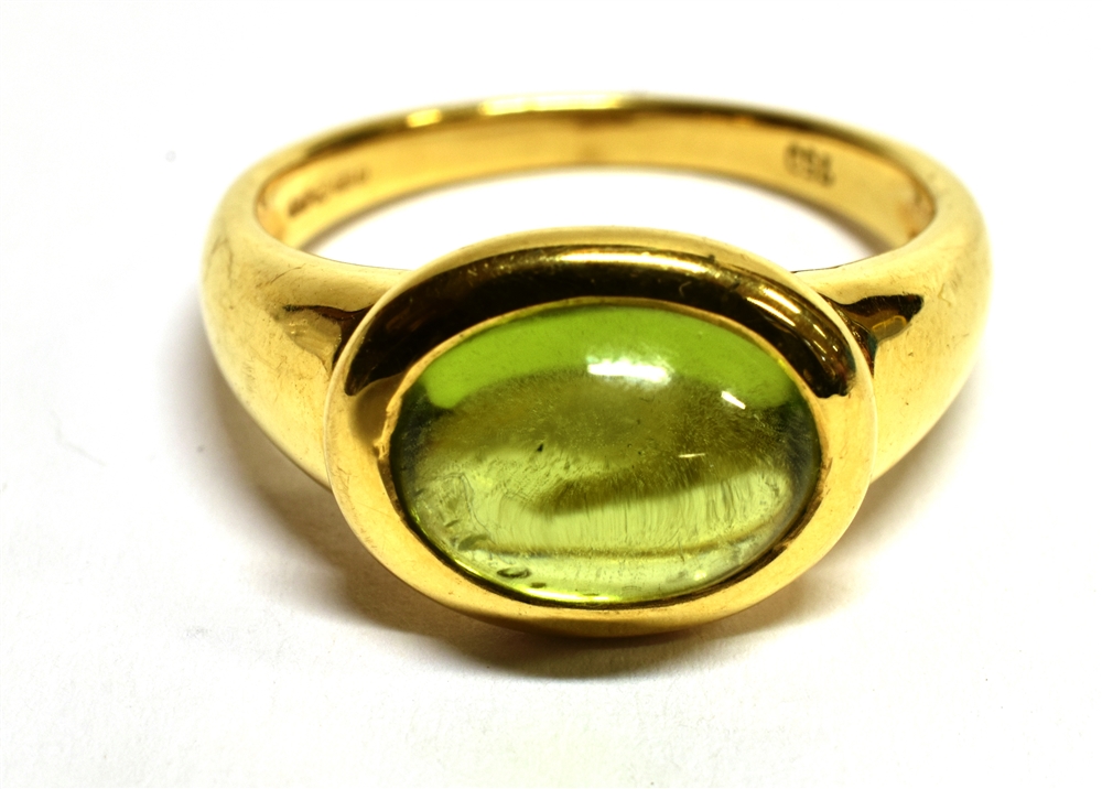 A PERIDOT SINGLE STONE 18 CARAT GOLD RING the oval cabochon cut peridot measuring approx. 10mm x