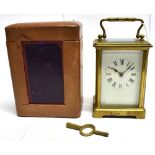 A BRASS CASED CARRIAGE CLOCK the enamel dial with Roman numerals, complete with carrying case
