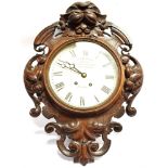 A LARGE WALL CLOCK IN HIGHLY CARVED OAK CASE with 8-day movement, the 12' enamel dial with Roman