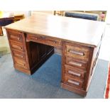 AN OAK TWIN PEDESTAL DESK each pedestal fitted with slide above four graduated drawers, further